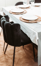 Les chaises en velours noir Rosy devant une table de salle à manger