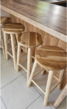 4 tabourets de bar en bois installé sous un ilot central dans la cuisine